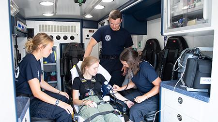 EMS student workers with a patient in the UMS vehicle